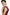 Model in ruffled scarlet mini dress, side view, soft fabric detail visible.