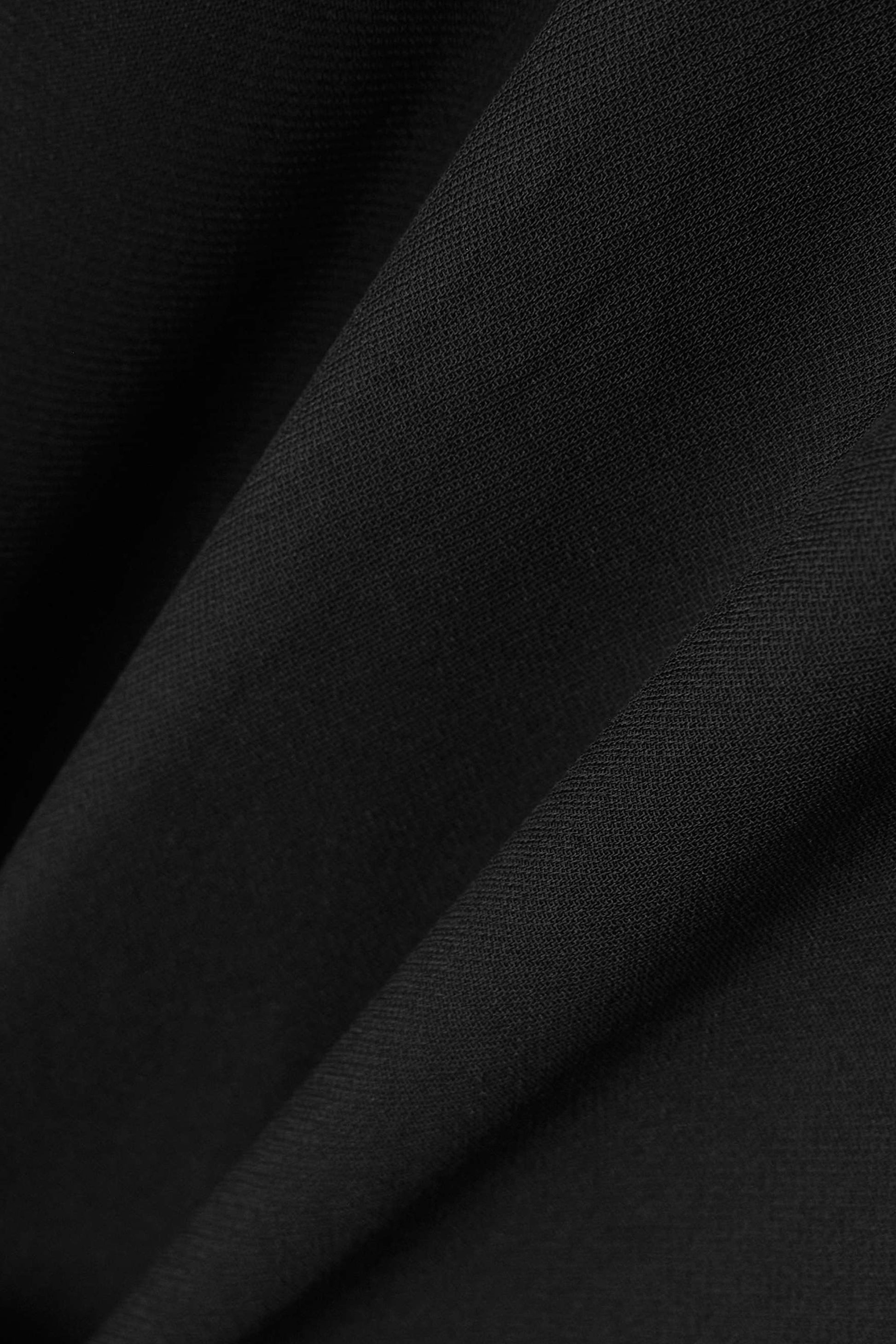 Close-up of black long sleeve maxi dress fabric texture, front view.