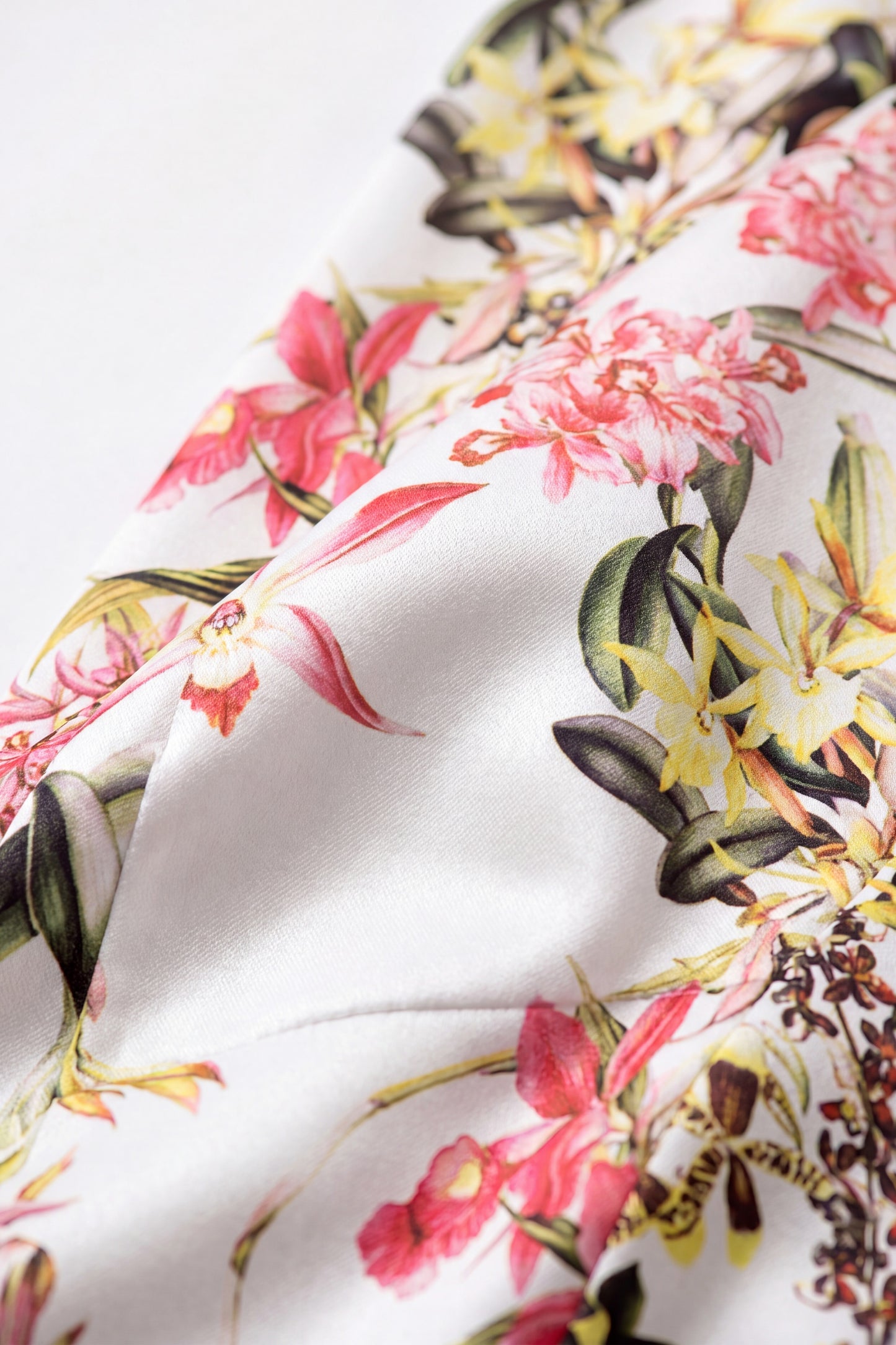 Close-up of jersey fabric with vibrant floral print, showcasing pink and yellow flowers.