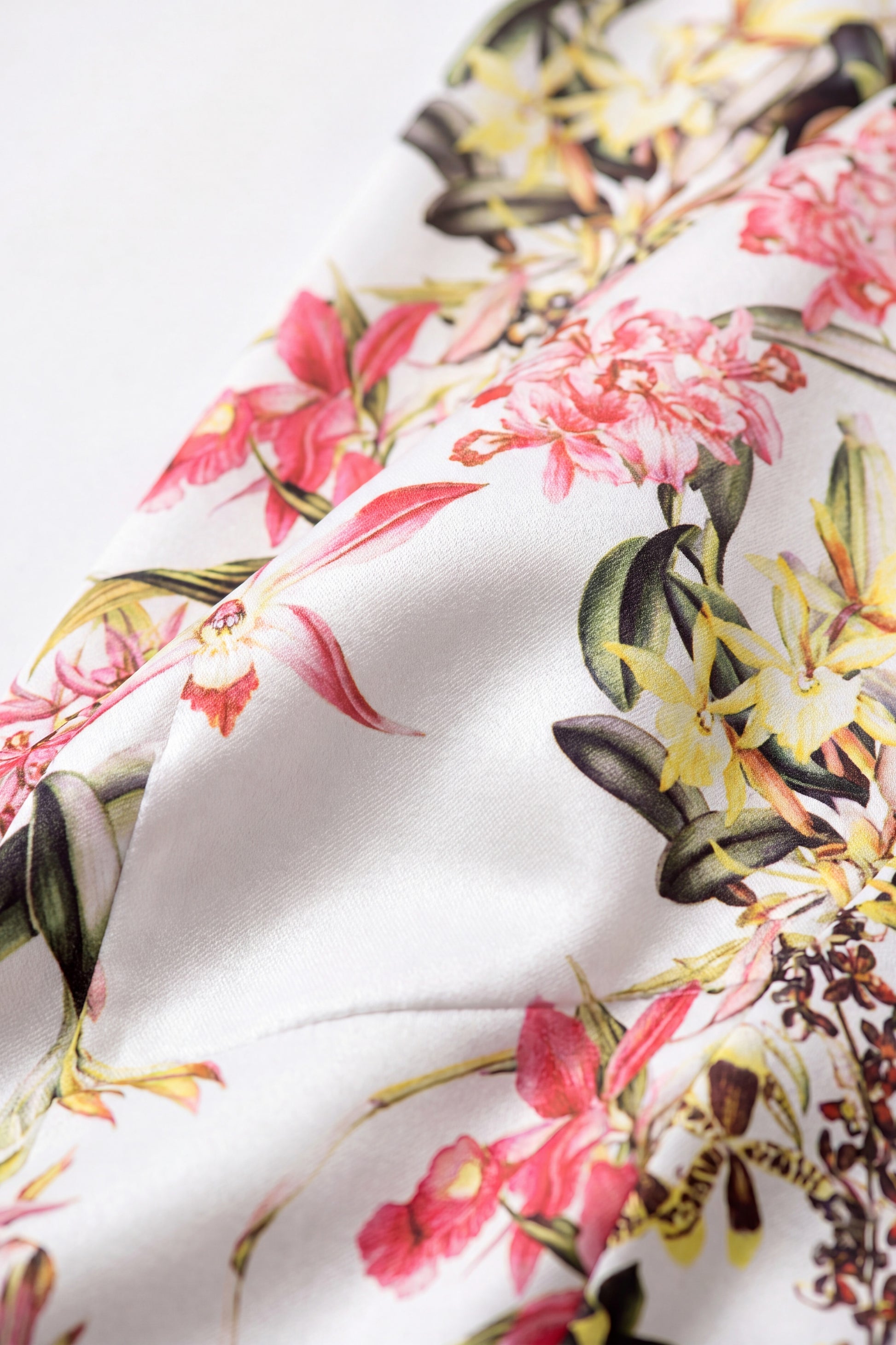 Close-up of jersey fabric with vibrant floral print, showcasing pink and yellow flowers.