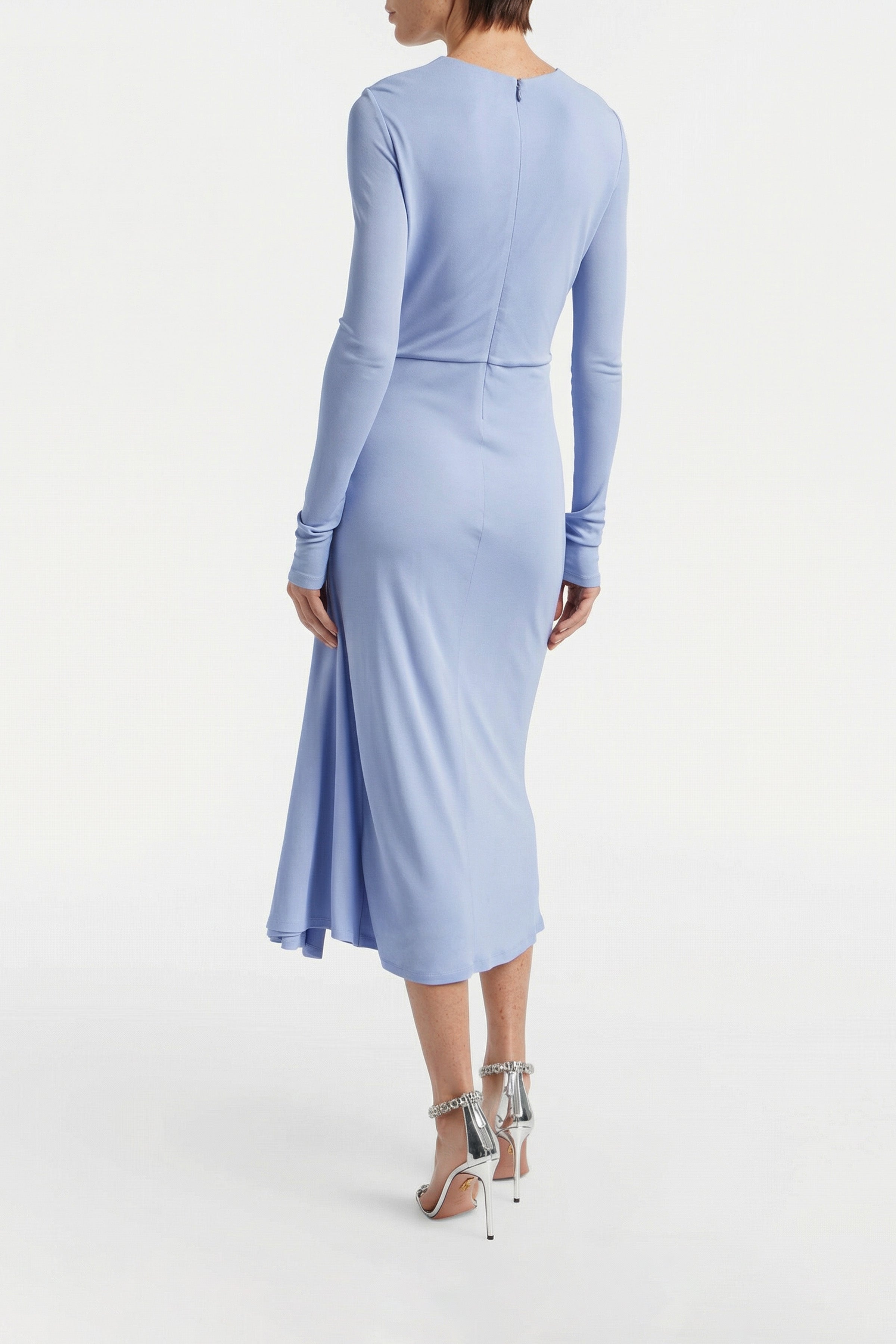Back view of model wearing sky blue draped midi dress with long sleeves.