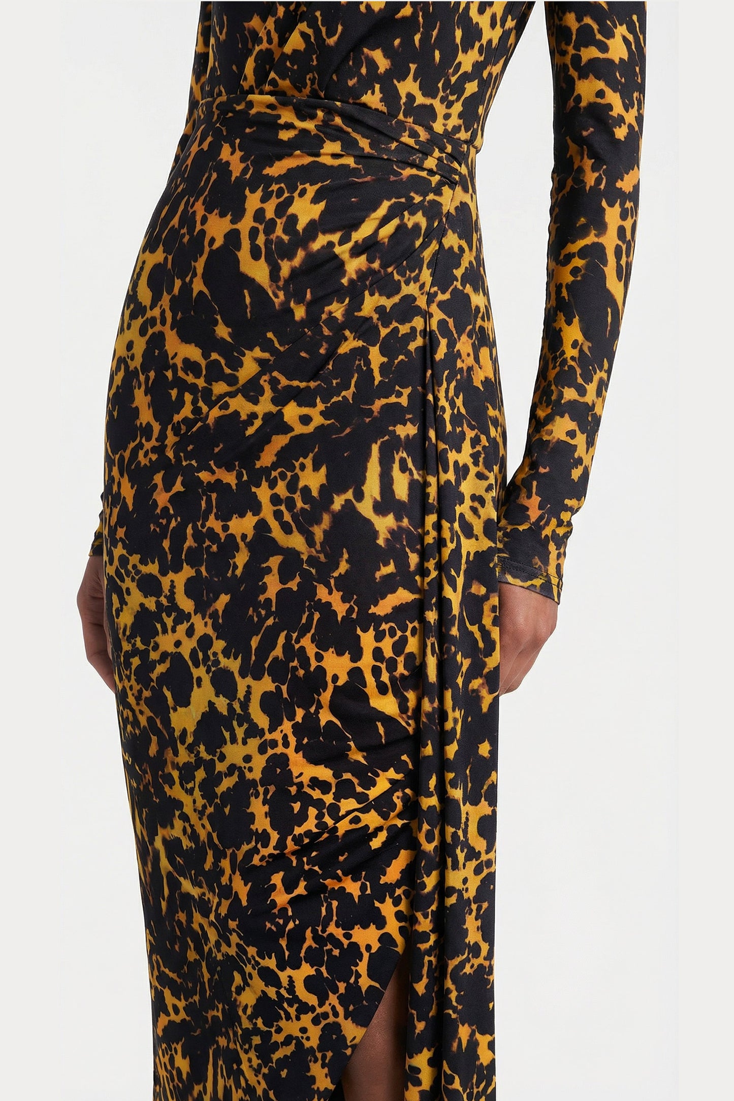 Detail shot of elegant side draping and abstract leopard-inspired pattern on a modern long-sleeved evening dress.