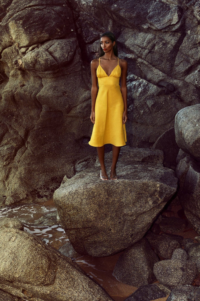 Mustard linen strap dresses with a fitted waist and flared skirt.