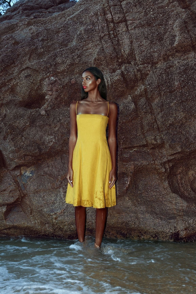 Mustard yellow linen bardot dresses with off-shoulder neckline and flared skirt.