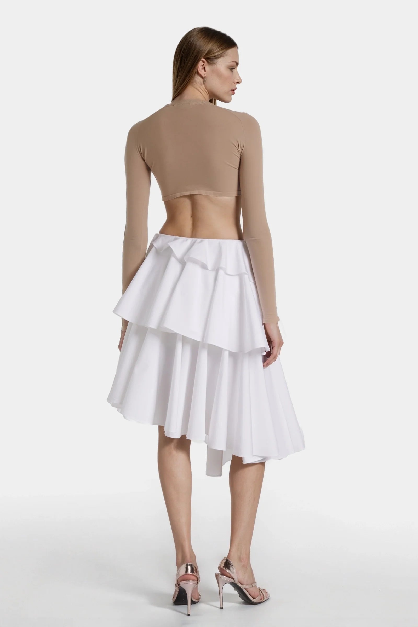 Side view showing wrap-around ruffles and angled hem of the skirt