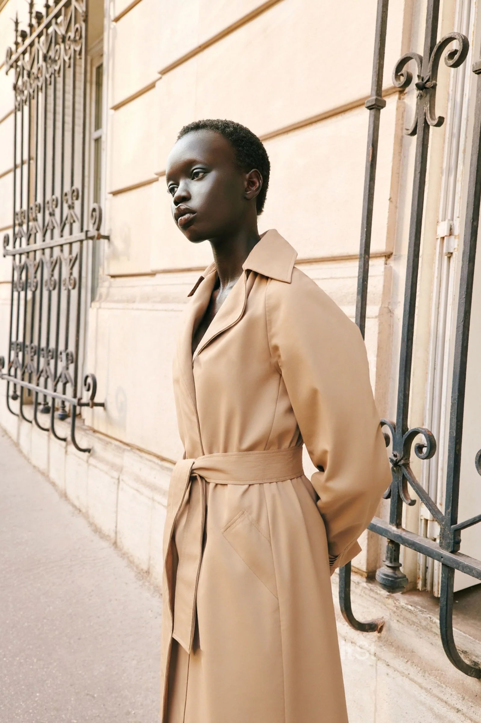 Elegant long beige trench coat with tie waist and minimalist design