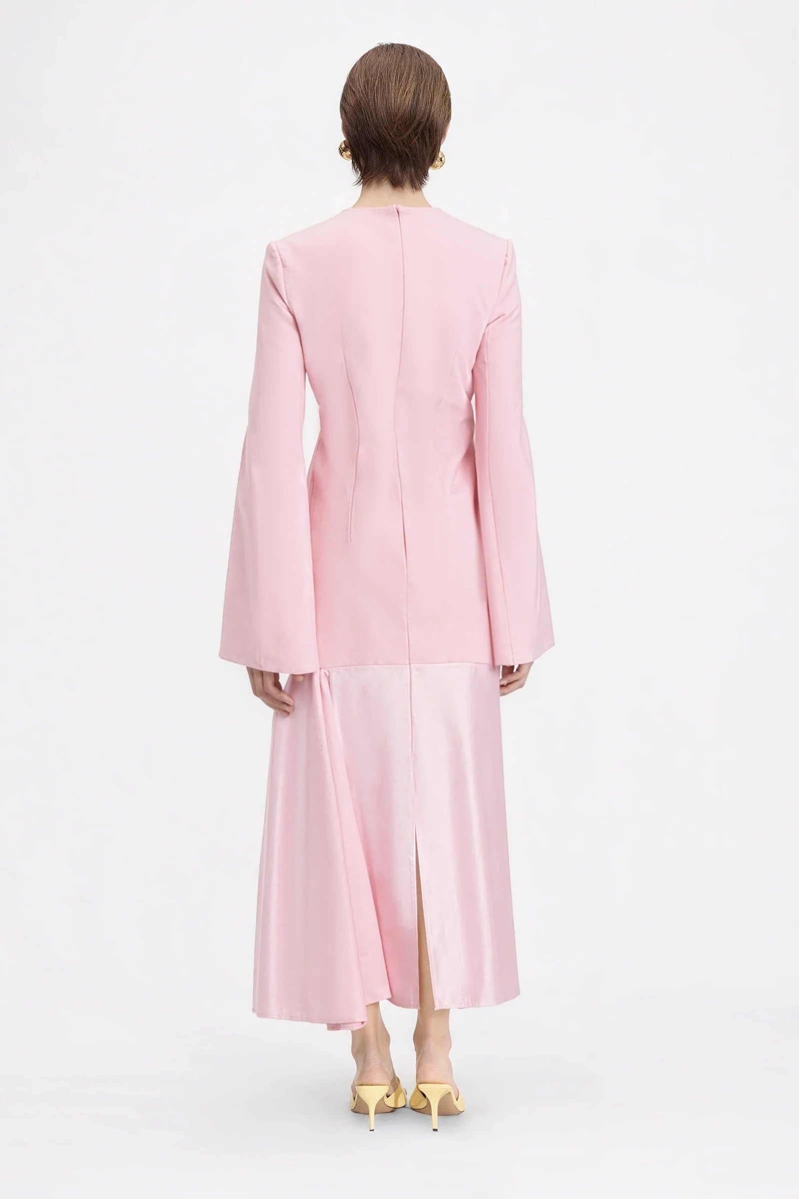Back view of the model wearing the pink dress, highlighting the flowing silhouette and ankle-length cut.