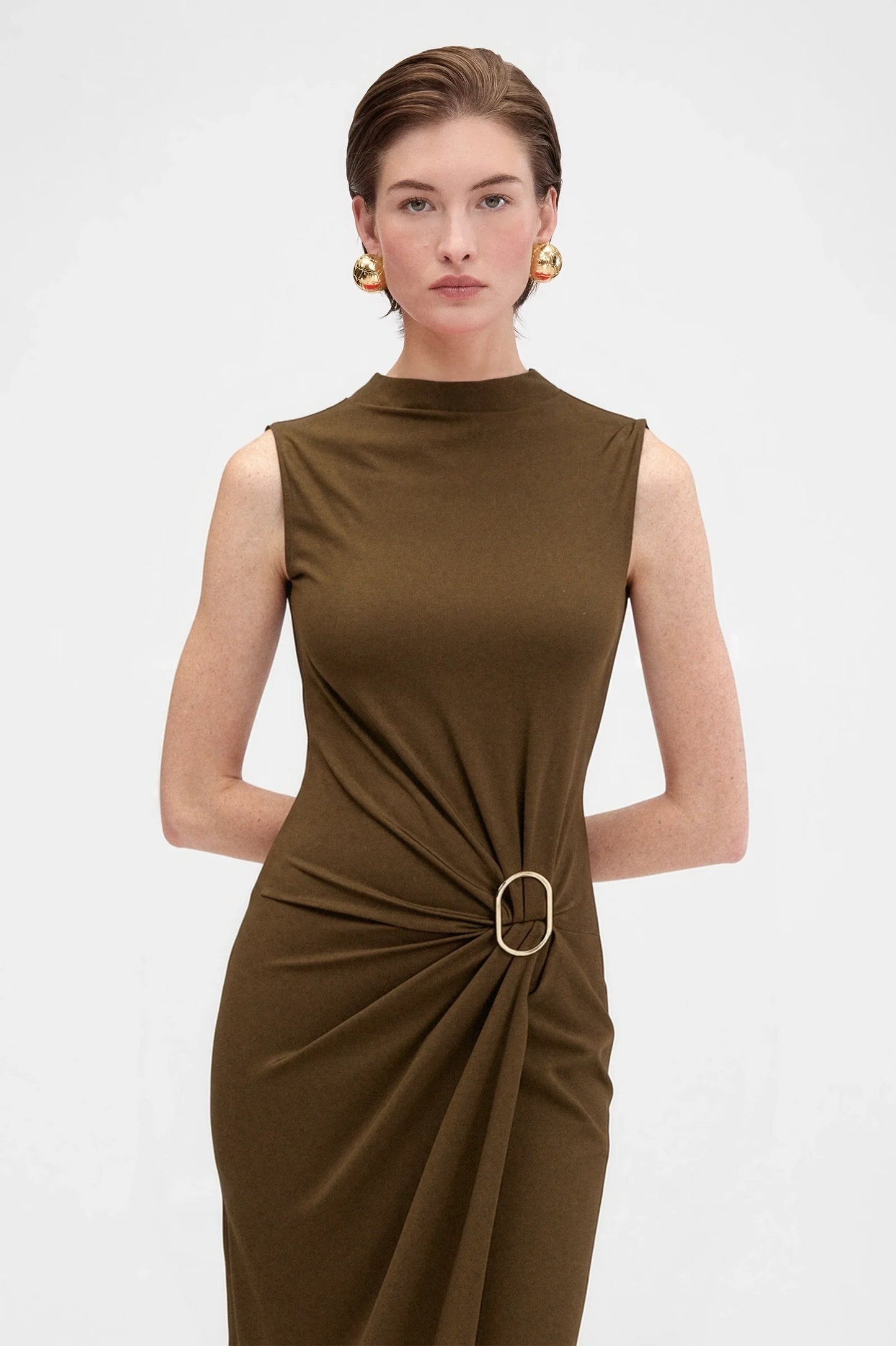 Close-up of sculptural ring gathering detail on elegant brown evening dress