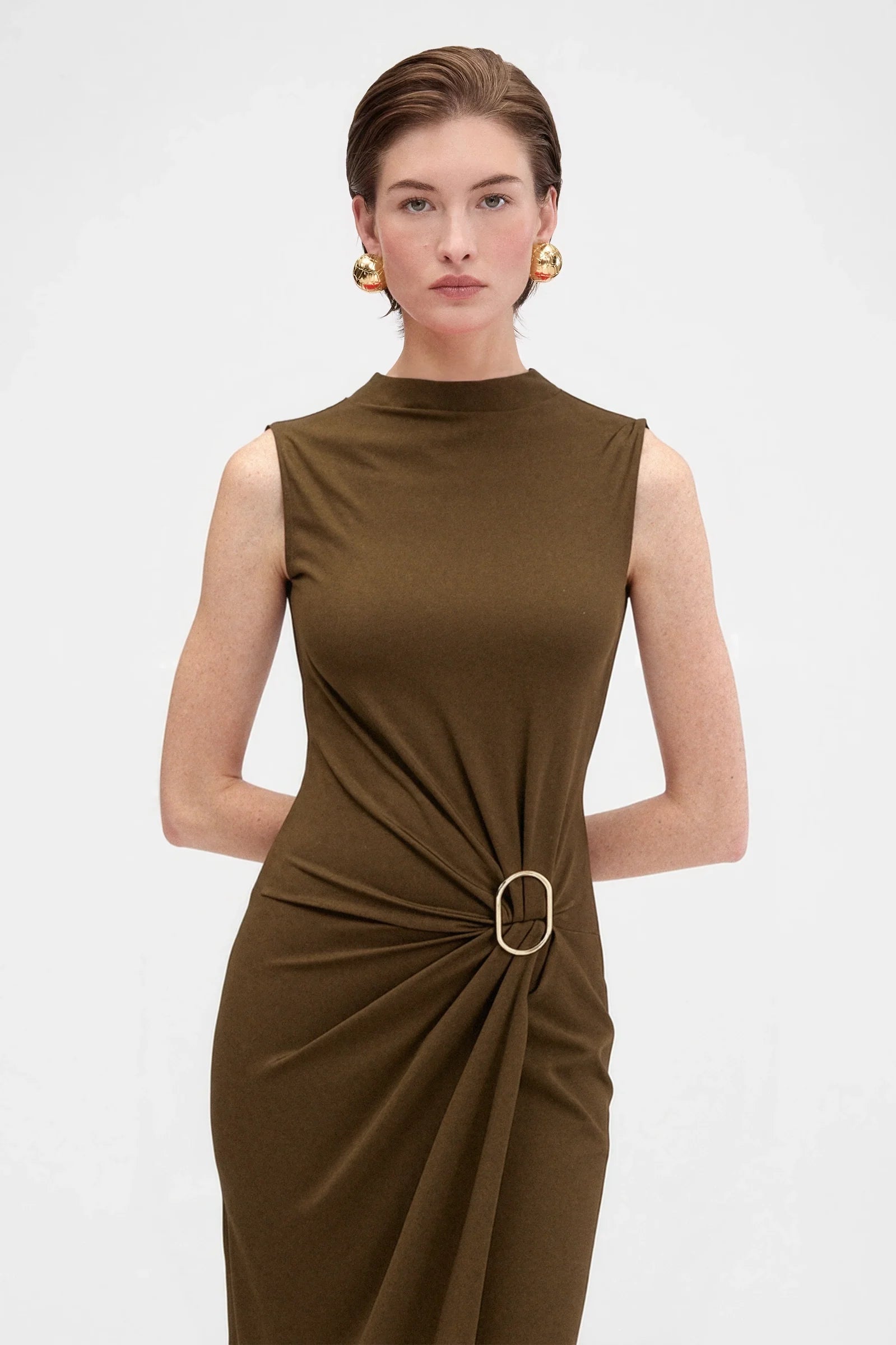 Close-up of sculptural ring gathering detail on elegant brown evening dress