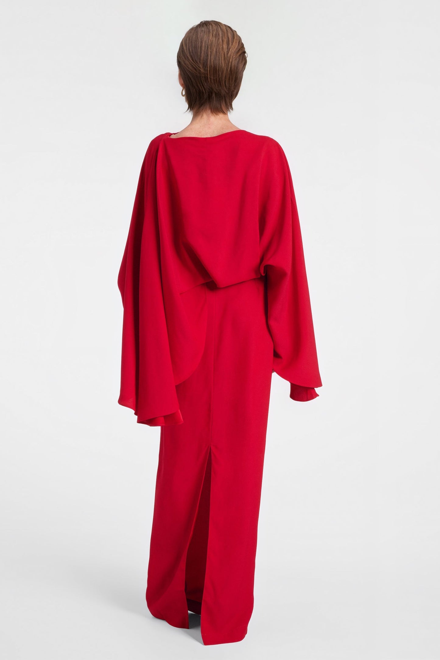 Back view of red crepe evening dress with cape sleeves.
