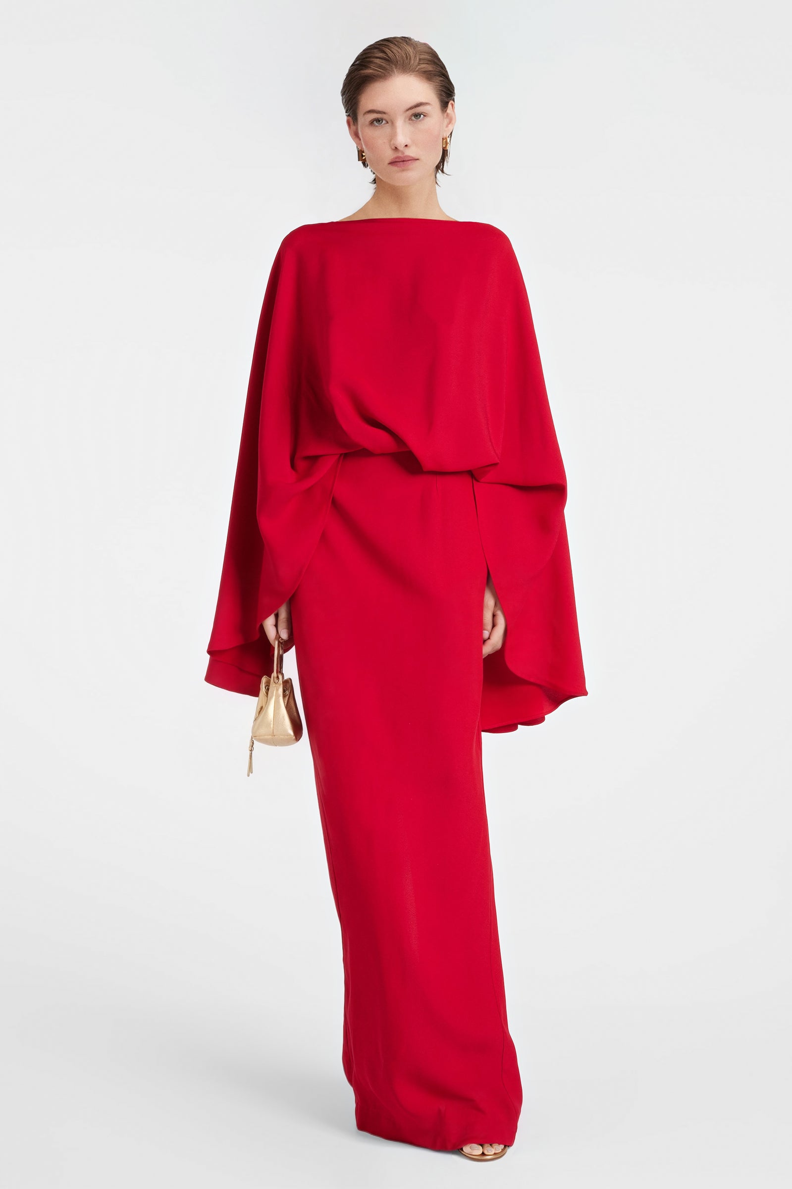 Elegant scarlet cape-style gown with fluid silhouette.