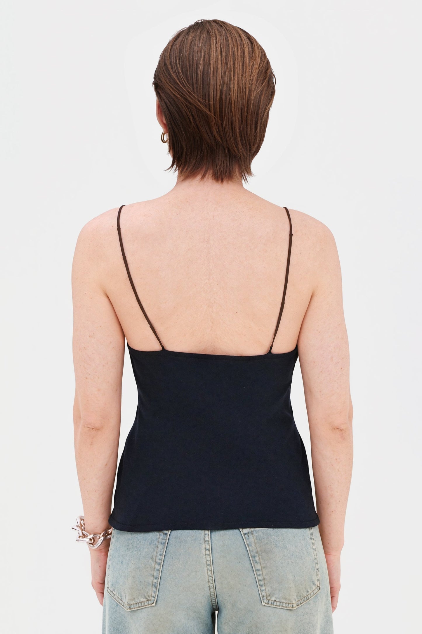 Back view of model in short cream halter dress, showing open back detail.