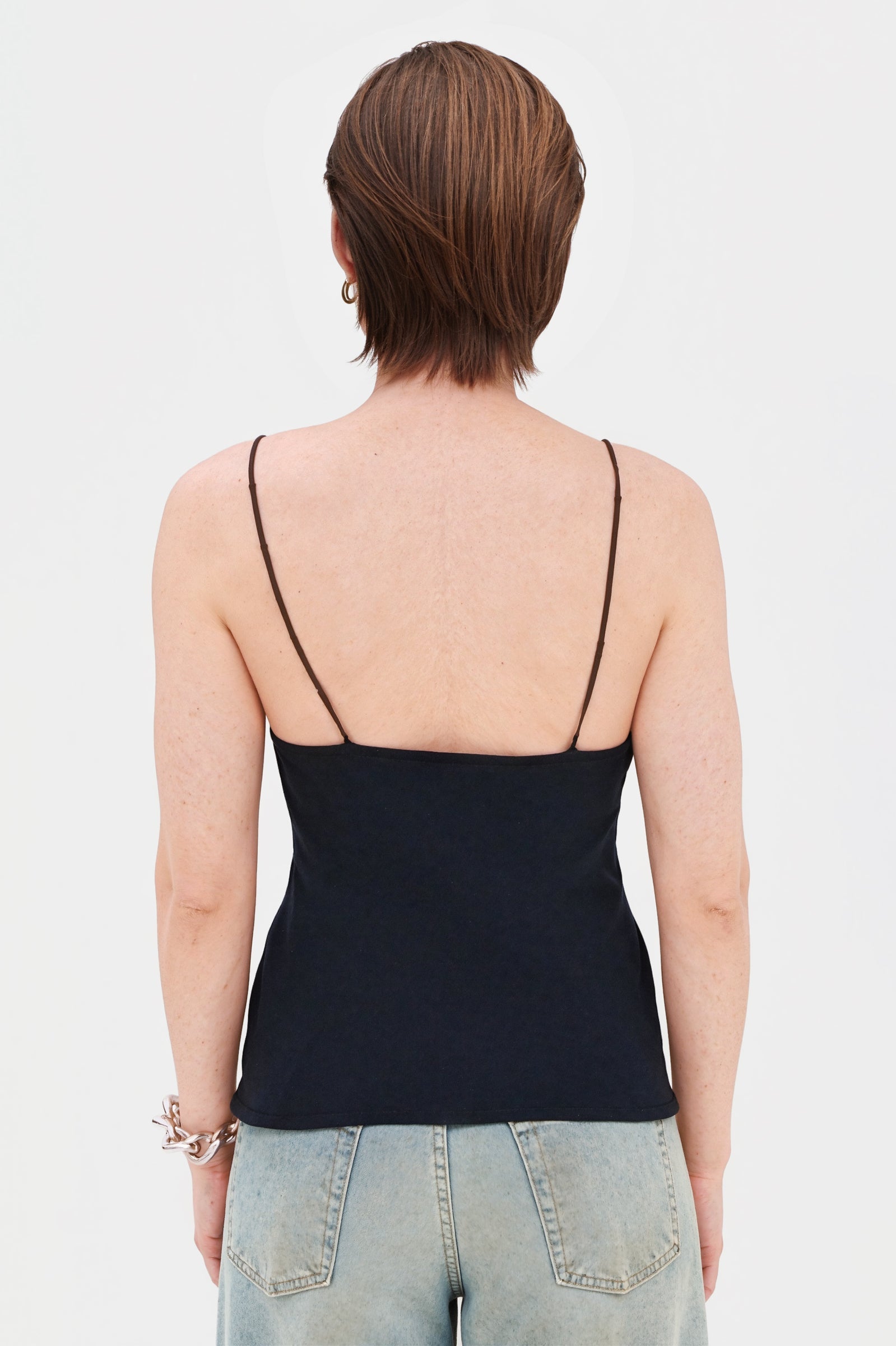 Back view of model in short cream halter dress, showing open back detail.