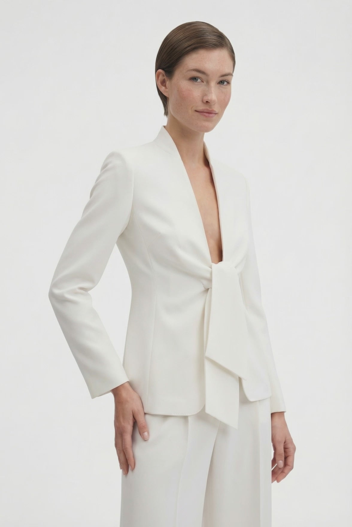 Model wearing ivory suit with tie-front detail, front view.