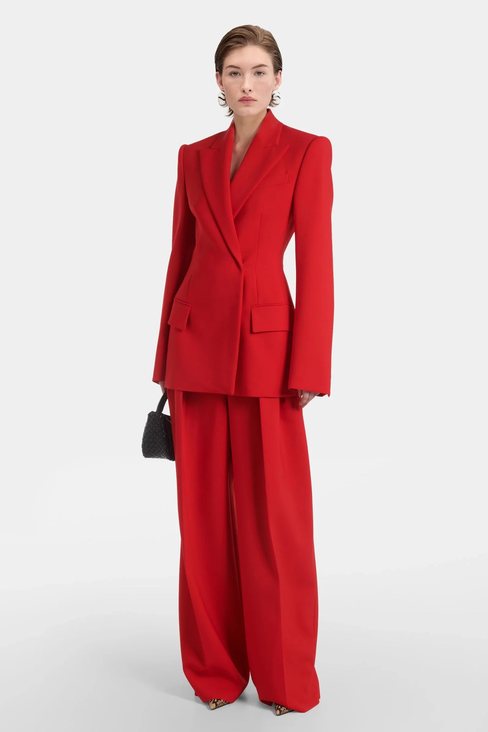 Model wearing red double-breasted tailored blazer with wide-leg trousers.