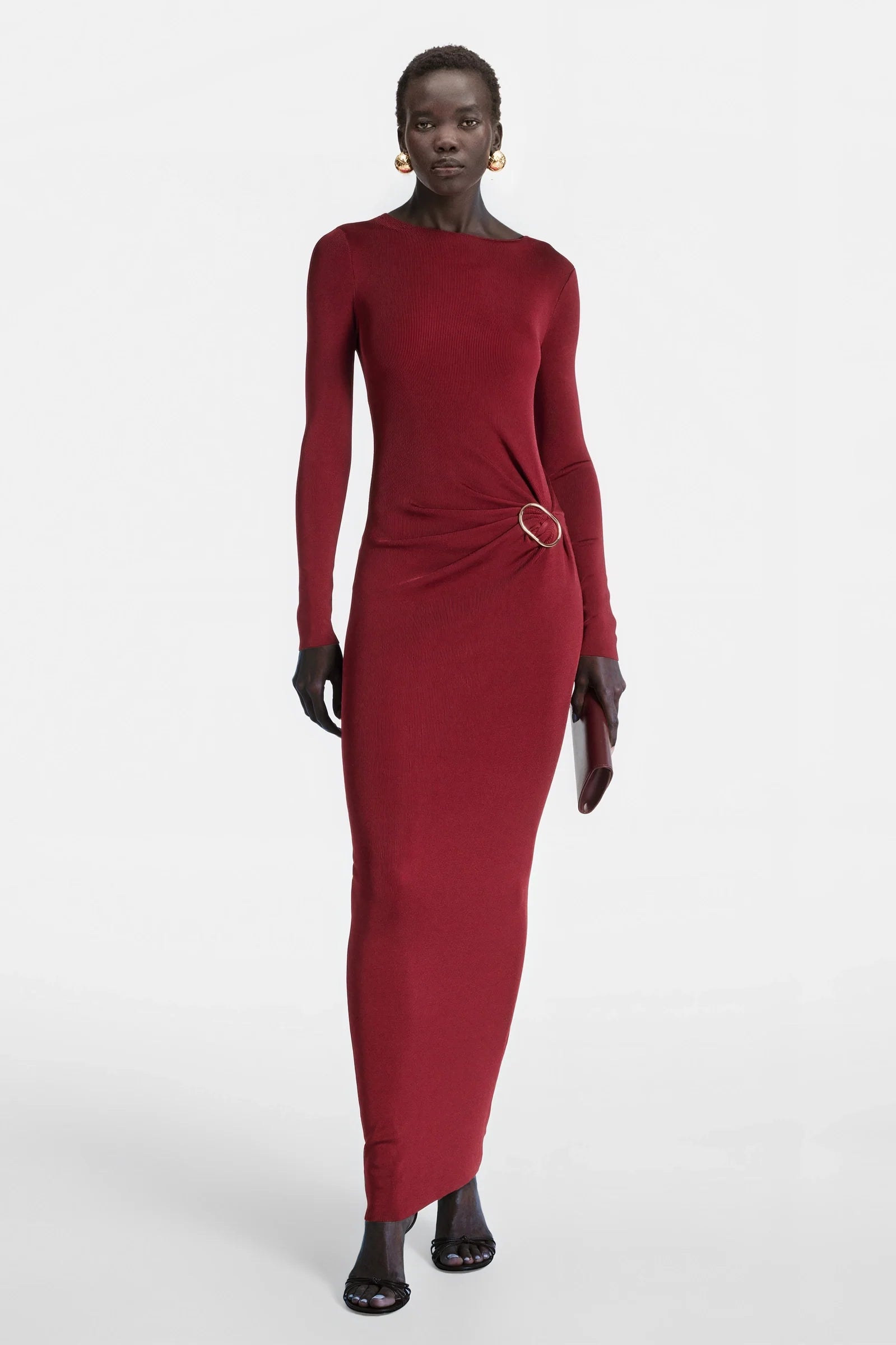 Model wearing red long sleeve ring dress by Felipe Albernaz