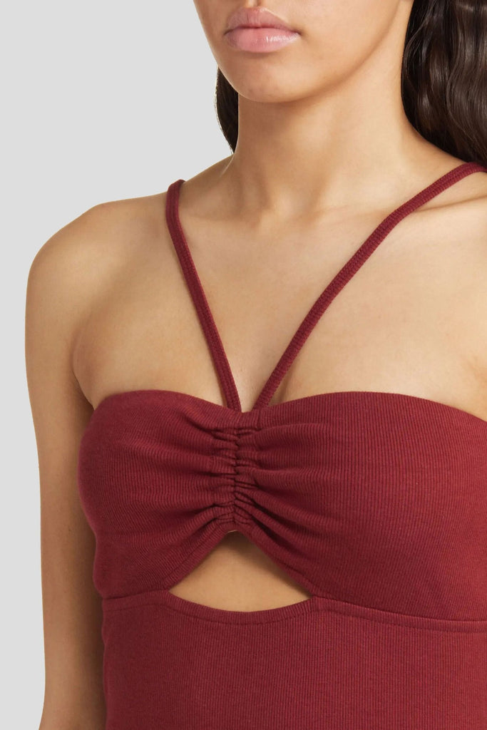 Fitted burgundy dresses with lingerie-inspired straps and cutout.